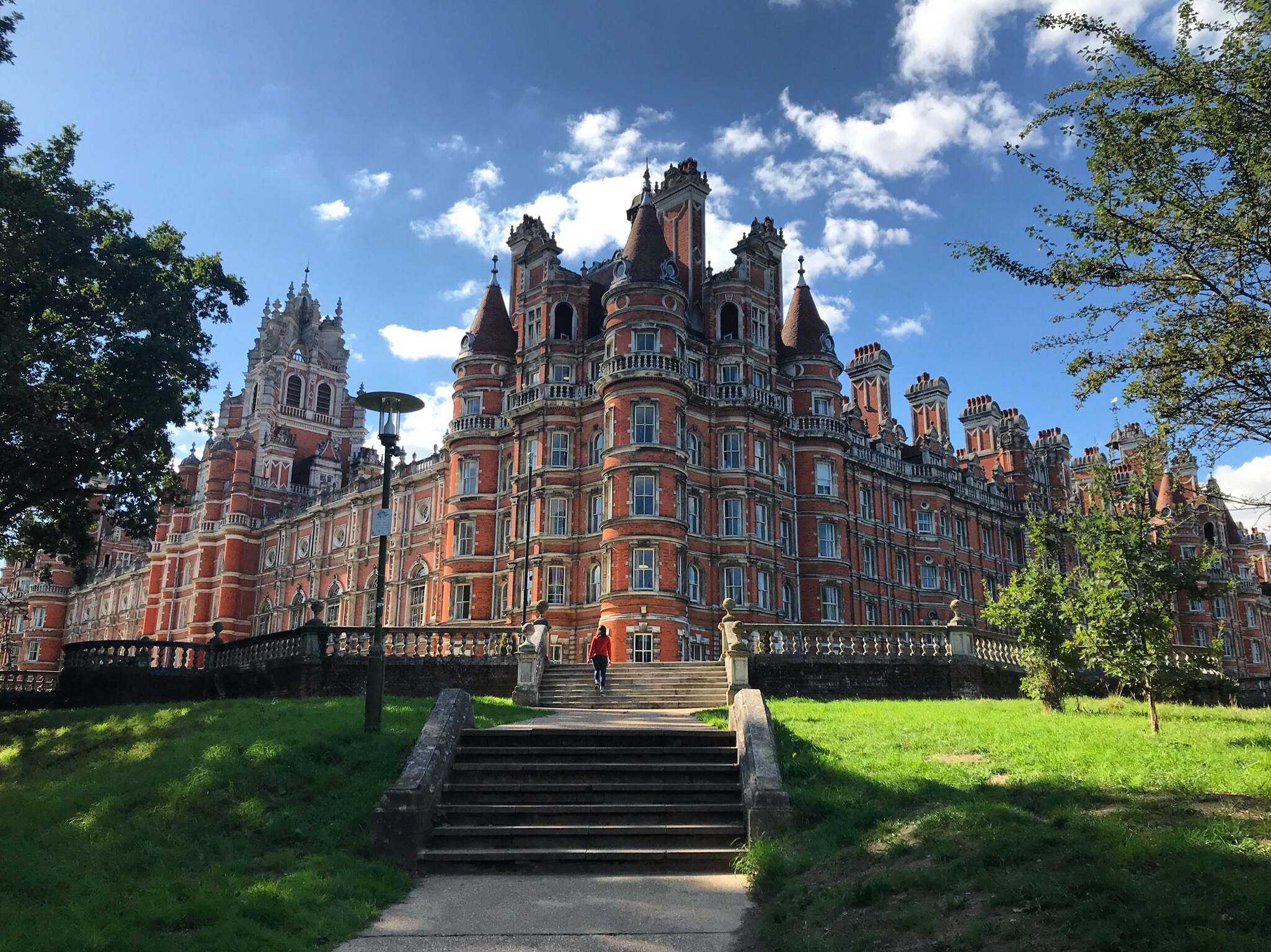 An imposing brick building under a blue sky. It has many chimneys and turrets.